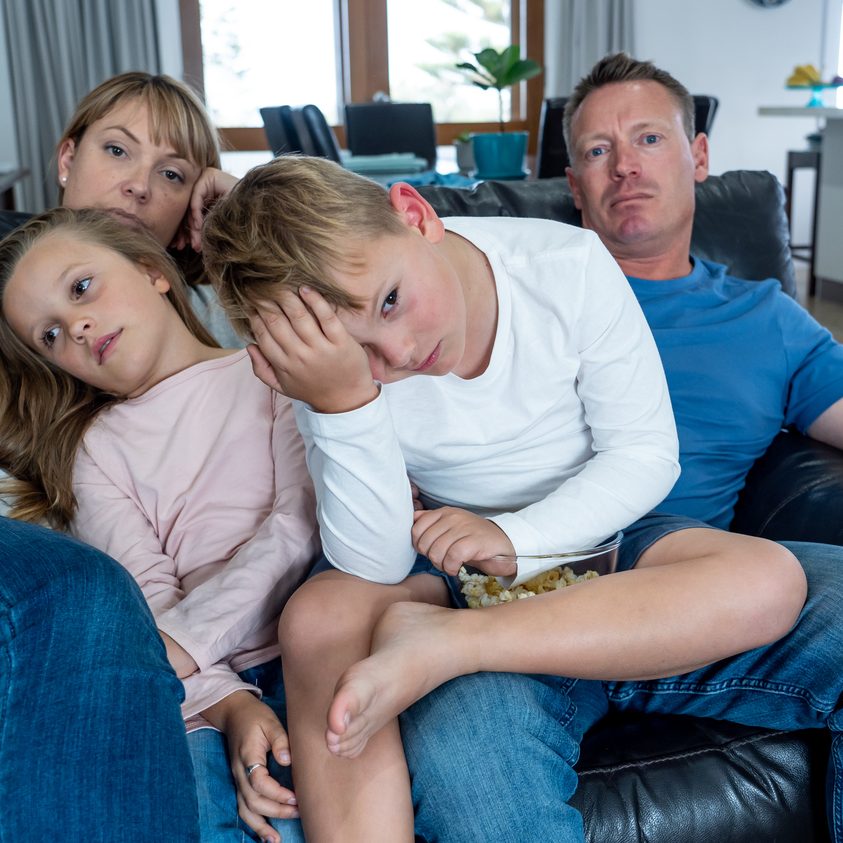 Coronavirus lockdow. Bored family watching tv helpless in isolation at home during quarantine COVID 19 Outbreak. Mandatory lockdowns and self isolation recommendations forces families stay home. 11