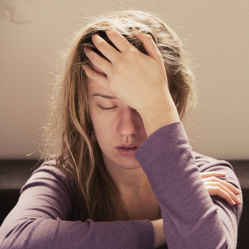 Woman suffering from stress or a headache grimacing in pain 11